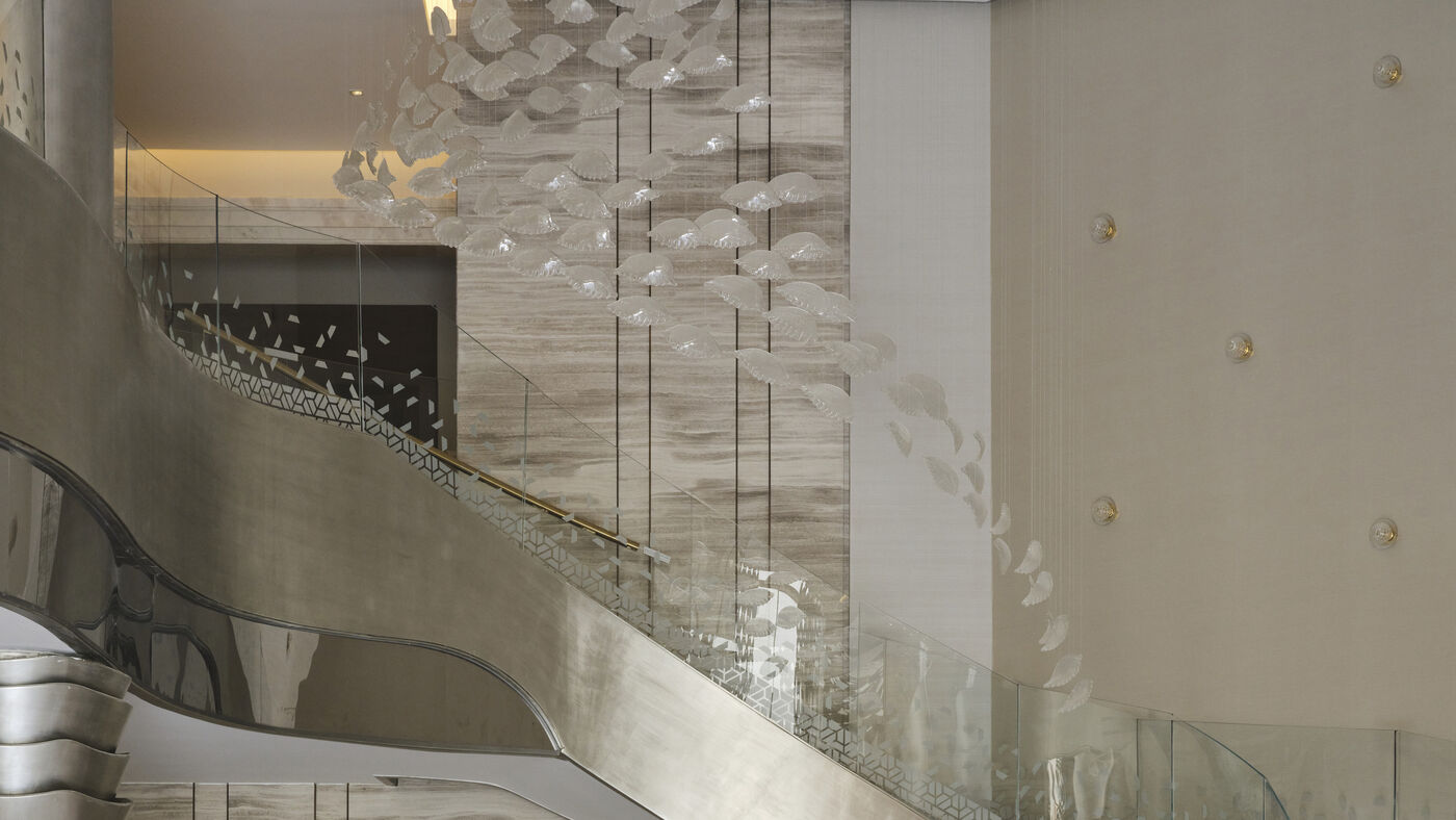 Curved staircase with glass balustrade and crystal installation